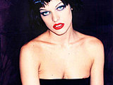 Milla Jovovich looks devilishly sexy in red panties on the bed
