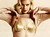 Claudia Schiffer holding her nude tits and golden bra posing pics