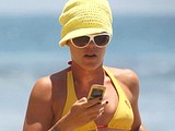 Pink topless & ass sunbathes on a beach